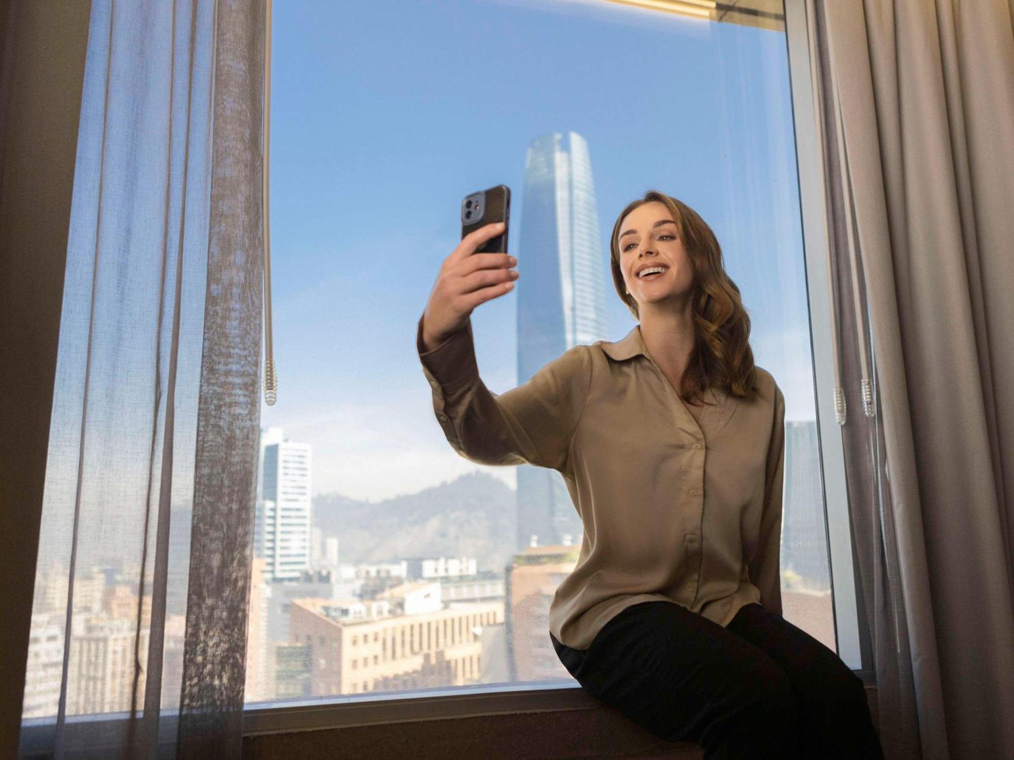 Hotel Pullman Santiago El Bosque Exterior foto A woman taking a selfie